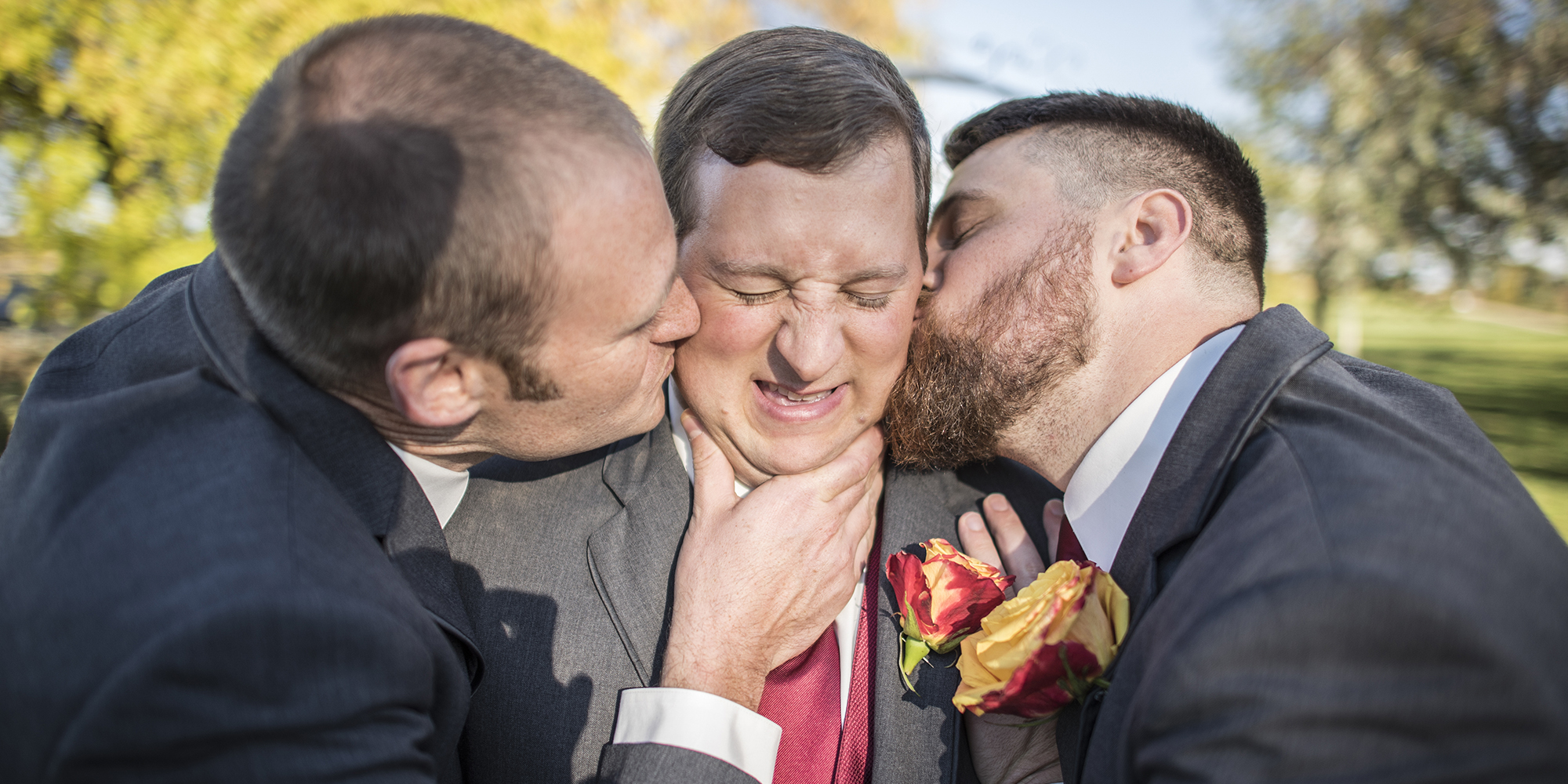 groomsmen kiss groom